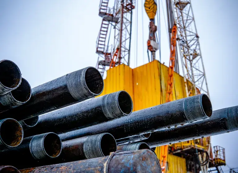 Oil Drill pipe. Rusty drill pipes were drilled in the well section. Downhole drilling rig. Laying the pipe on the deck. View of the shell of drill pipes laid in courtyard of the oil and gas warehouse.